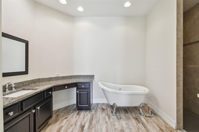 bathroom with hardwood / wood-style floors, a bathtub, and vanity