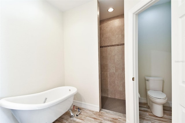 bathroom featuring plus walk in shower, hardwood / wood-style floors, and toilet