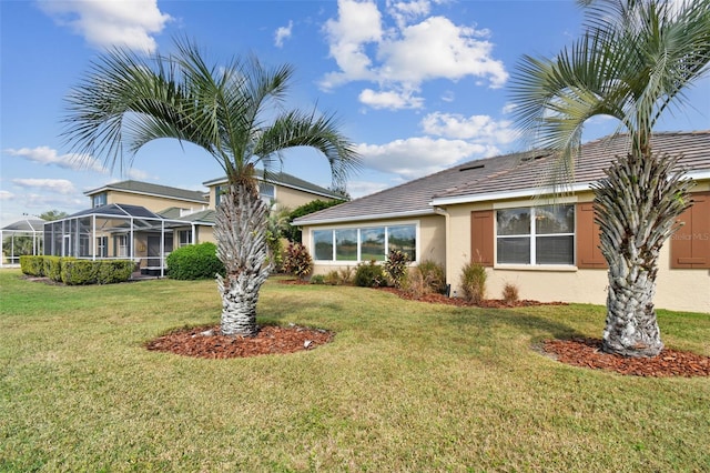 view of front of home featuring glass enclosure and a front lawn