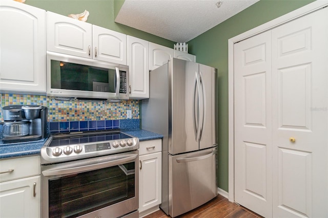 kitchen featuring tasteful backsplash, white cabinetry, a textured ceiling, and appliances with stainless steel finishes