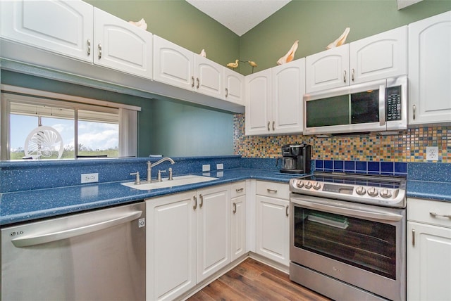 kitchen with white cabinets, appliances with stainless steel finishes, tasteful backsplash, and sink