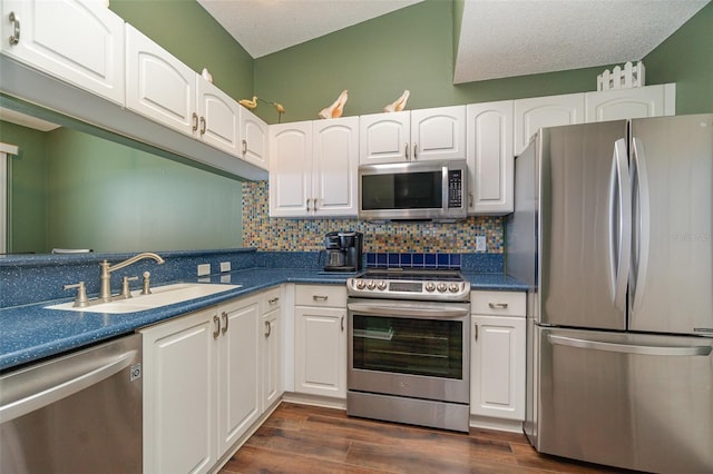 kitchen featuring white cabinetry, sink, stainless steel appliances, a textured ceiling, and decorative backsplash