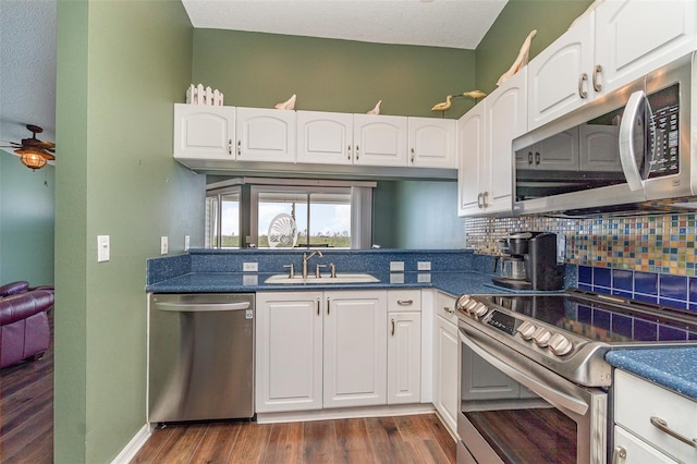 kitchen featuring backsplash, white cabinets, sink, ceiling fan, and appliances with stainless steel finishes