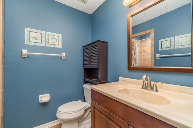 bathroom featuring vanity, toilet, and a textured ceiling