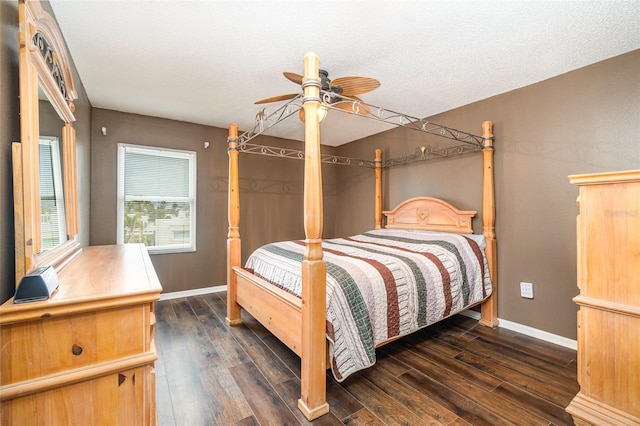 bedroom with ceiling fan, dark wood-type flooring, and a textured ceiling