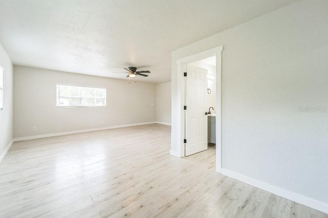 empty room with ceiling fan and light hardwood / wood-style flooring