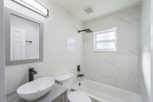 full bathroom featuring toilet, tiled shower / bath, and vanity