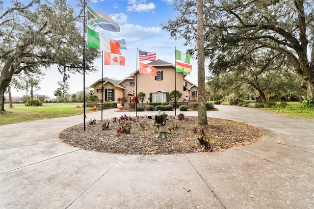 view of front of house with curved driveway and stucco siding