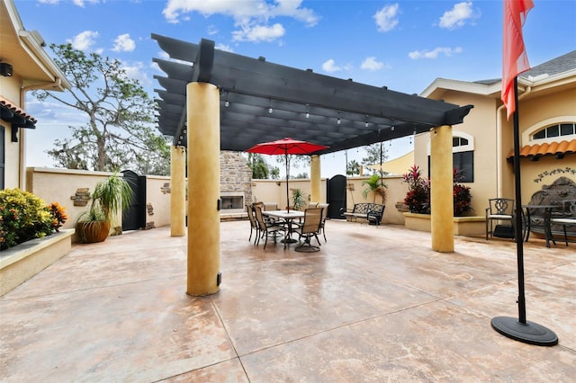 view of patio / terrace featuring a fenced backyard, exterior fireplace, a pergola, and outdoor dining space