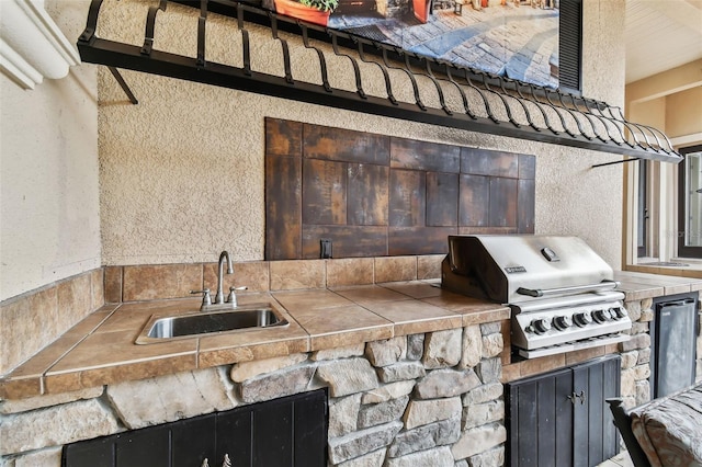 view of patio / terrace featuring area for grilling, sink, and an outdoor kitchen