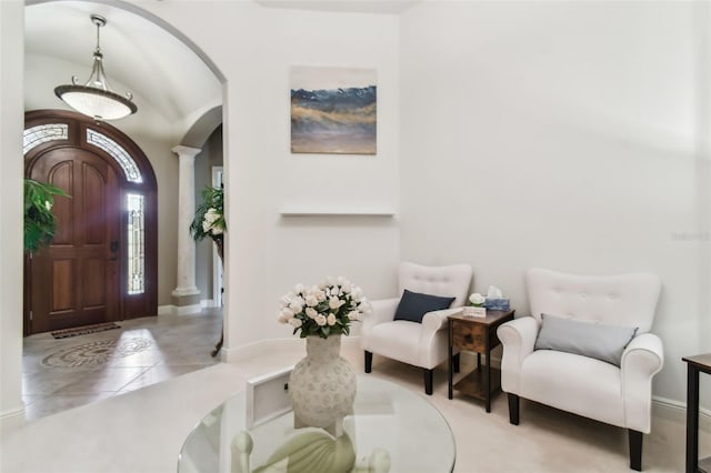 foyer with arched walkways, ornate columns, and light tile patterned floors