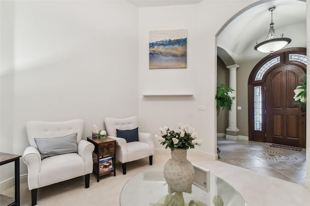 entrance foyer featuring arched walkways, decorative columns, and baseboards