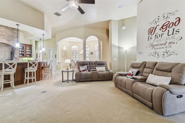 living area with light carpet, high vaulted ceiling, visible vents, and ornate columns