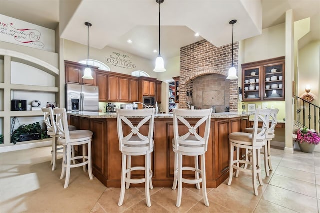 kitchen featuring light stone countertops, hanging light fixtures, light tile patterned flooring, and stainless steel appliances