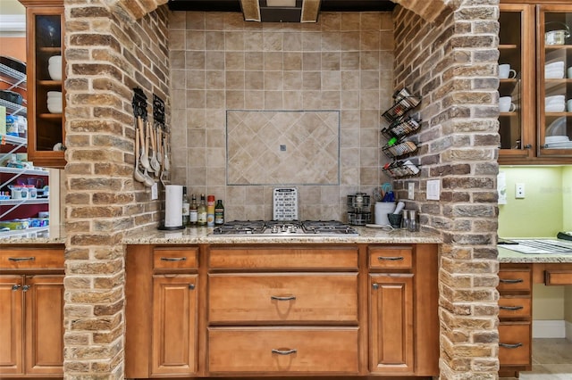 bar featuring stainless steel gas cooktop and decorative backsplash