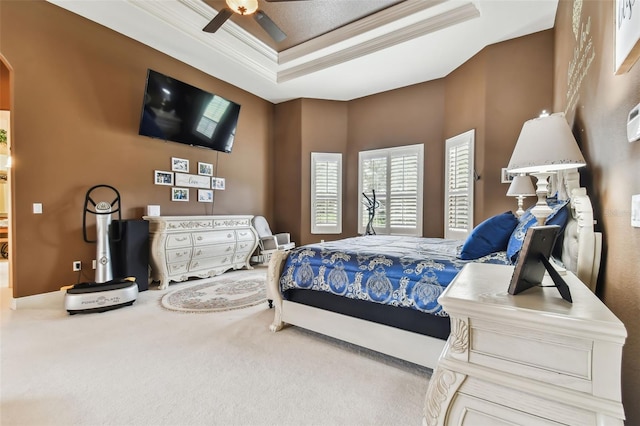 carpeted bedroom with a ceiling fan, arched walkways, a raised ceiling, and crown molding