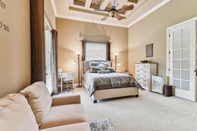 carpeted bedroom featuring a high ceiling, a tray ceiling, ceiling fan, and ornamental molding