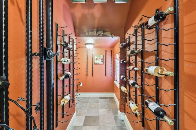 wine room featuring stone finish flooring and baseboards