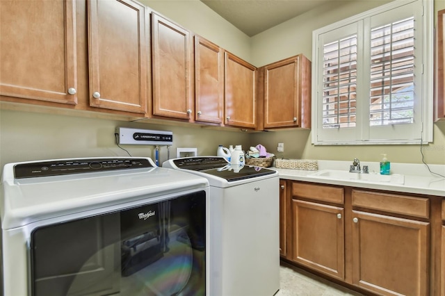 washroom with a sink, cabinet space, and washer and dryer