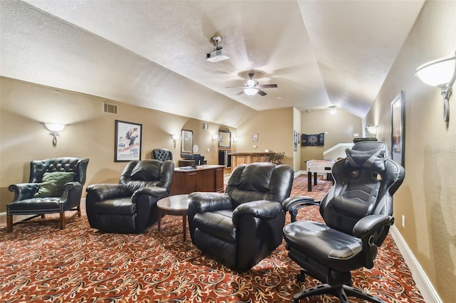 carpeted home theater room featuring visible vents, a ceiling fan, vaulted ceiling, a textured ceiling, and baseboards