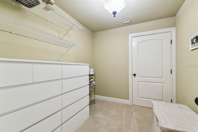 walk in closet with light colored carpet