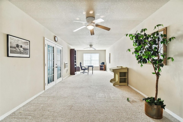 hallway featuring carpet, baseboards, a textured ceiling, and french doors