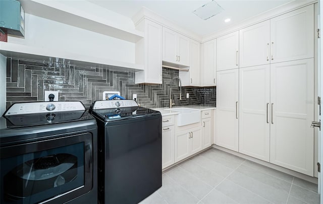 laundry area featuring cabinets, light tile patterned floors, separate washer and dryer, and sink