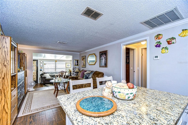 dining room featuring hardwood / wood-style floors, a textured ceiling, and ornamental molding