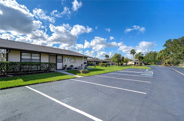 view of parking / parking lot with a yard