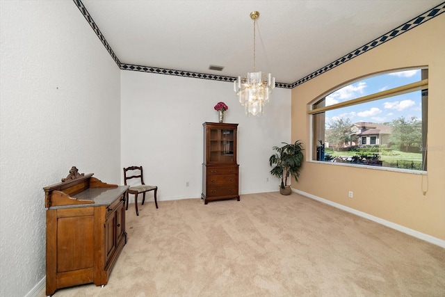 living area featuring light colored carpet and an inviting chandelier