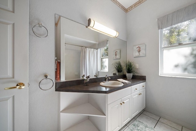 bathroom featuring vanity, tile patterned floors, a healthy amount of sunlight, and crown molding