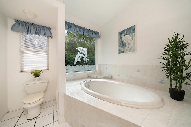 bathroom featuring tile patterned flooring, tiled bath, and toilet