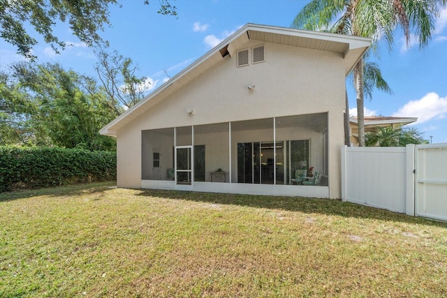 rear view of property with a sunroom and a lawn