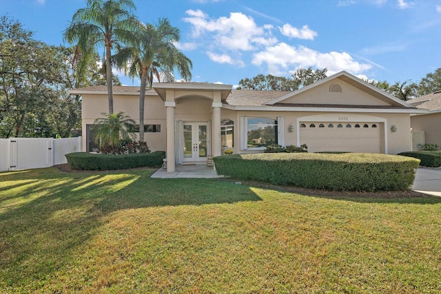 view of front facade with french doors, a front lawn, and a garage