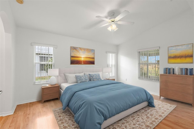 bedroom with ceiling fan, wood-type flooring, and lofted ceiling