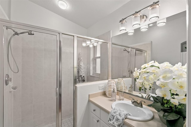 bathroom with a shower with door, vanity, and lofted ceiling