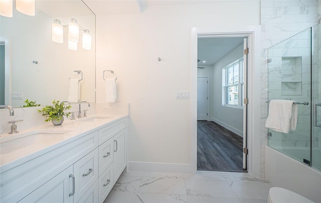 full bathroom featuring combined bath / shower with glass door, hardwood / wood-style floors, vanity, and toilet