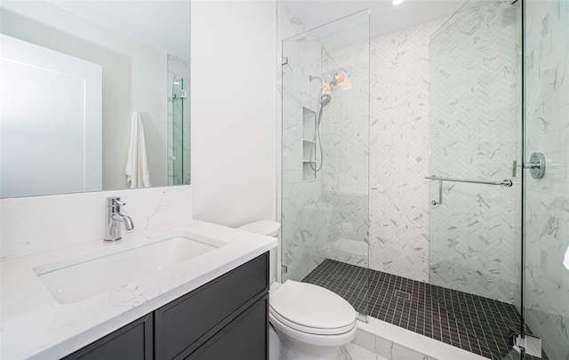 bathroom featuring vanity, an enclosed shower, and toilet