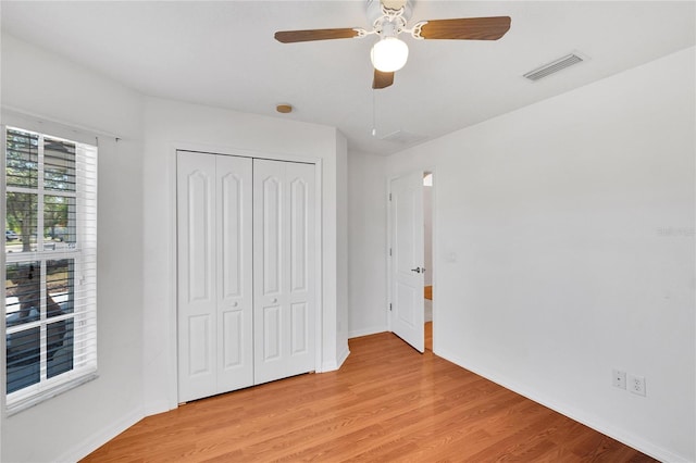 unfurnished bedroom with a closet, light hardwood / wood-style floors, and ceiling fan