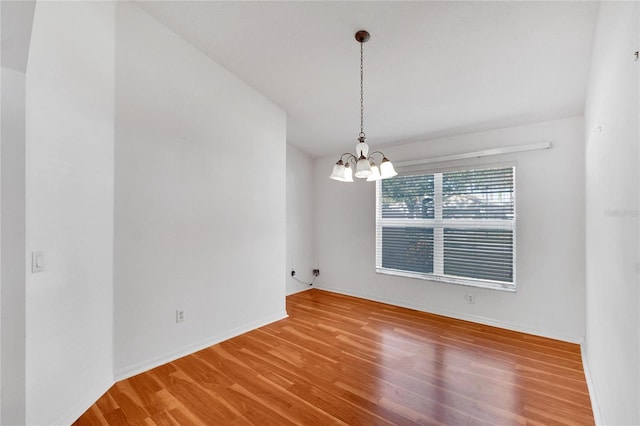 unfurnished dining area featuring wood-type flooring and a notable chandelier