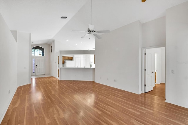 unfurnished living room featuring ceiling fan, light wood-type flooring, and high vaulted ceiling