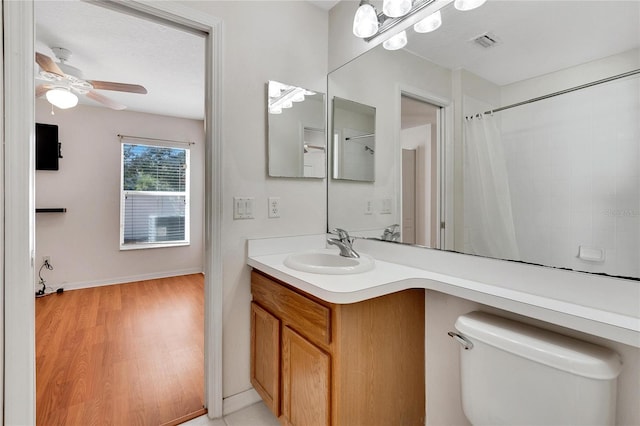 bathroom featuring hardwood / wood-style floors, ceiling fan, toilet, and vanity