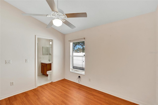 unfurnished bedroom with ensuite bath, ceiling fan, light hardwood / wood-style floors, and vaulted ceiling