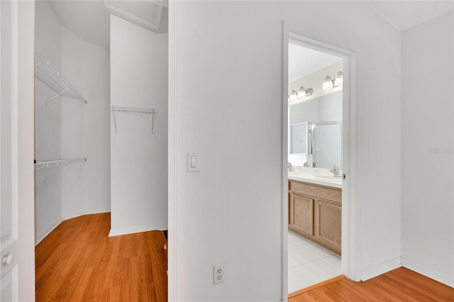 spacious closet featuring sink and light hardwood / wood-style floors