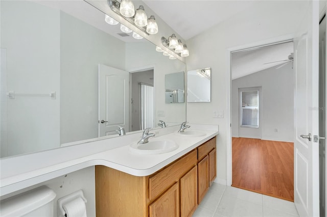 bathroom with vanity, lofted ceiling, ceiling fan, toilet, and wood-type flooring