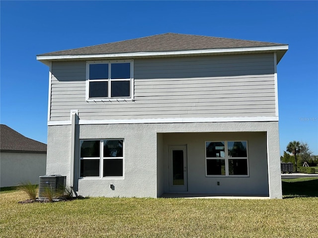 rear view of house with a lawn and central AC