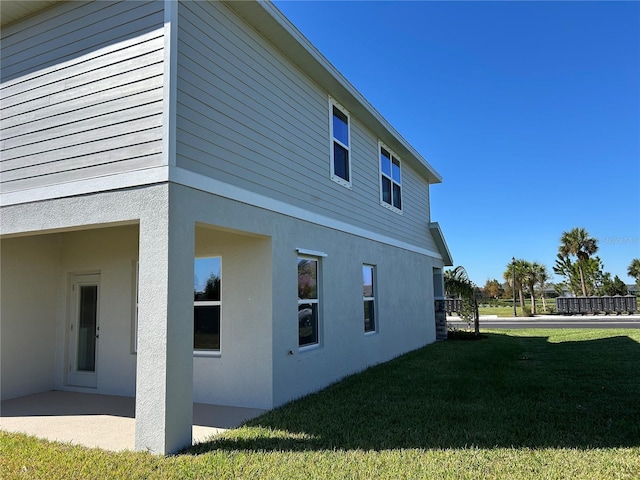 view of side of property with a yard and a patio