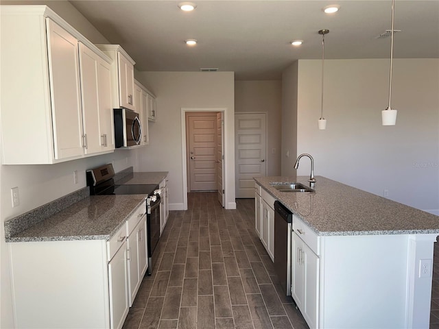 kitchen with white cabinetry, stainless steel appliances, light stone counters, dark hardwood / wood-style flooring, and decorative light fixtures