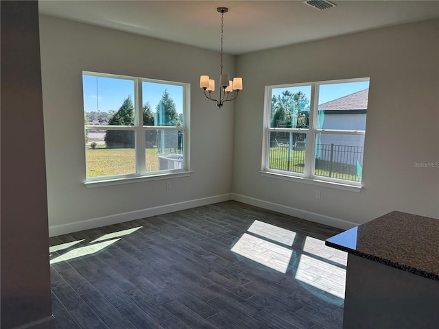 unfurnished dining area with a chandelier and dark wood-type flooring