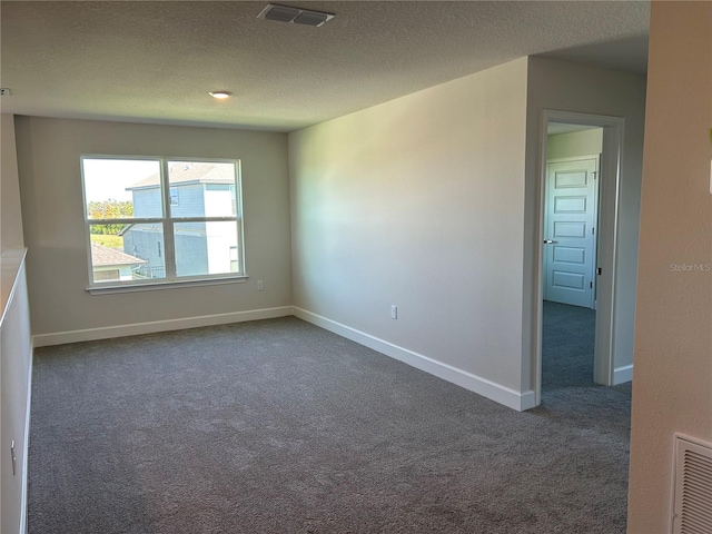 unfurnished room featuring dark colored carpet and a textured ceiling